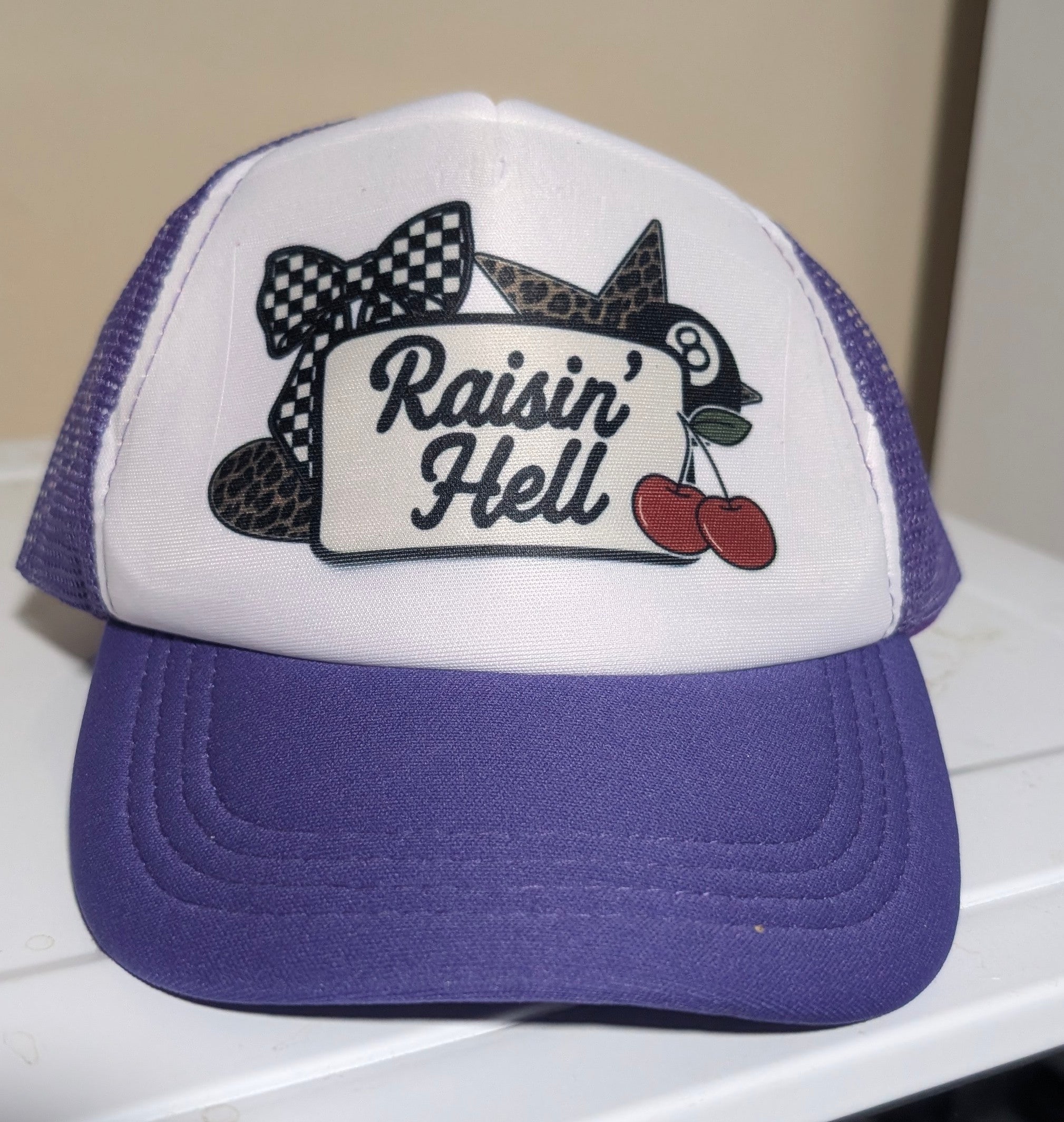 Raisin’ Hell – Purple & White Sublimated Trucker Hat